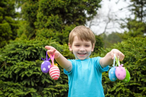 Uova di Pasqua di colore diverso nelle mani di un bambino- caccia alle uova — Foto Stock