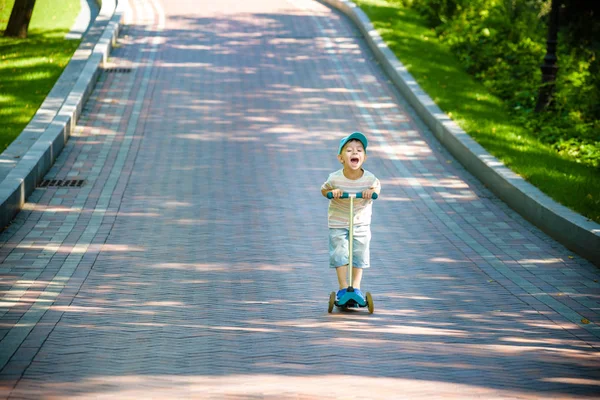 Хлопчик грає на скутері в місцевому парку — стокове фото