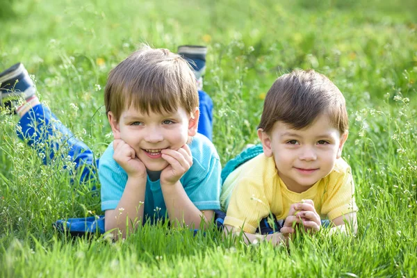 Glückliches Kind genießt sonnigen Spätsommer- und Herbsttag in der Natur auf grünem Gras. — Stockfoto