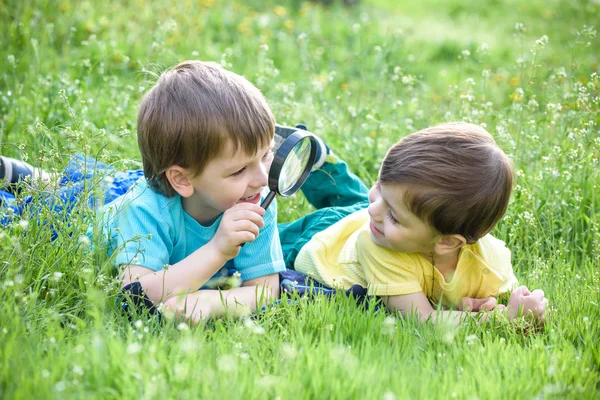 Dos hermanos varones con lupa al aire libre . — Foto de Stock