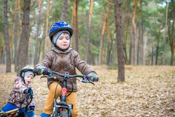 Dwoje rodzeństwa trochę zabawy na rowery w fore jesienią lub wiosną — Zdjęcie stockowe