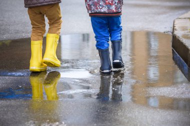 mutlu çocuklar yağmur altında atlama