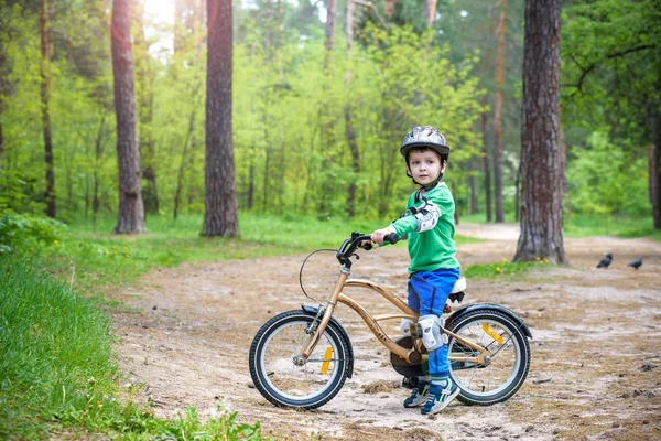 Happy cute blond kid chłopiec zabawy jego pierwszy rower na słoneczny summ — Zdjęcie stockowe