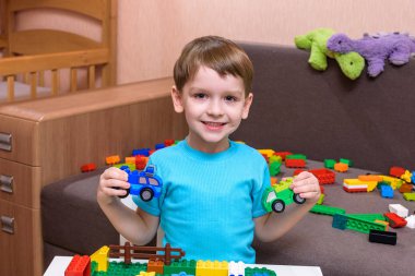 Renkli plastik blok kapalı birçok ile oyun küçük çocuk. Oluşturma bina çocuk çocuk giyen gömlek ve sahip eğlence