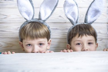 Üzerine yumurta oynamak bunny kulaklar giyen iki sevimli küçük kardeş avlamak 