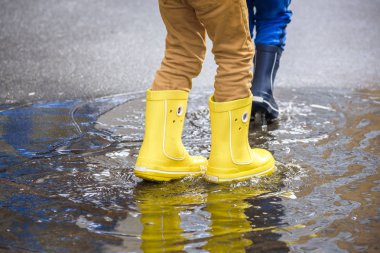 mutlu çocuklar yağmur altında atlama