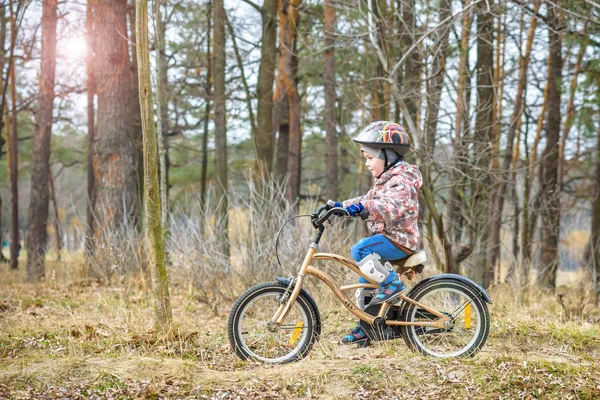 Dziecko na rowerze w wcześnie rano w lesie. Chłopiec na rowerze o — Zdjęcie stockowe