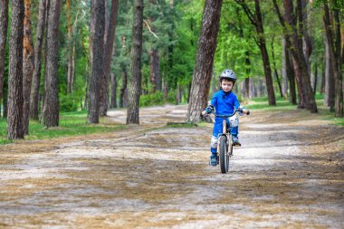 Sevimli sarışın çocuk mutlu çocuk ilk güneşli summ bisikletiyle eğleniyor