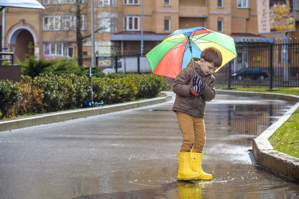 Mały chłopiec, grając w deszczowe lato park. Dziecko z kolorowe rai — Zdjęcie stockowe