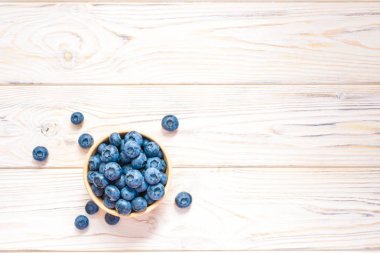 Yaban mersini bir ahşap kase. Üstten Görünüm. Olgun ve lezzetli yaban mersini ahşap arka plan üzerinde