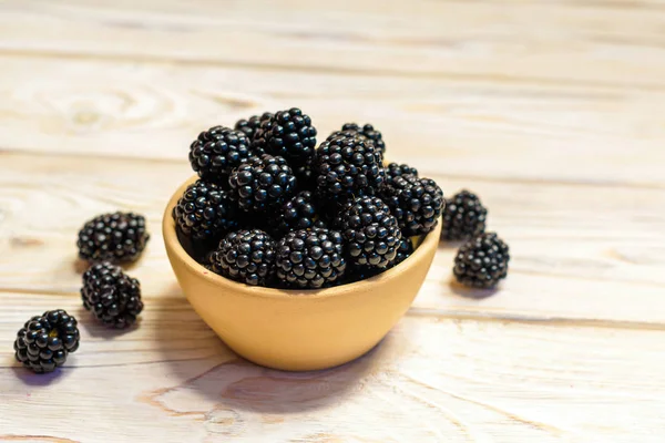 Close up of ripe blackberries in a white ceramic bowl over rustic wooden background — Stock Photo, Image