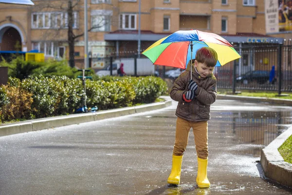 Little boy playing in rainy summer park. Child with colorful rai — Stock Photo, Image