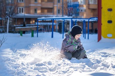 Karda atlama çocuk. Mutlu bir çocukluk açık havada kış şehirde yürüyüş. Çocuk gülen ve having fun.