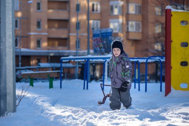 Açık havada kış şehirde yürüyüş çocuk mutlu onun kızak sürükler. Çocuk gülen ve having fun.