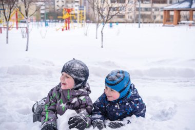 Karda oturan iki Çocuk Bahçesi peyzaj kaplı. Kış ağaçlarıyla ve buz, dağ görünümünde arka plan.