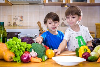 Sağlıklı beslenme. Mutlu çocuk hazırlar ve sebze salatası yiyor