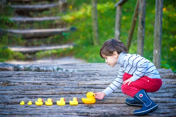 Adorable niño, niño, jugando en el parque con patos de goma, teniendo f — Foto de Stock