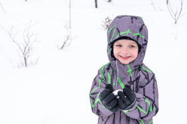 Sevimli küçük çocuk çocuk kar melek yapma renkli kış giysileri içinde