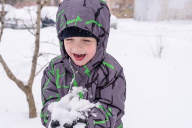 Çocuk karı elinde tutuyor.