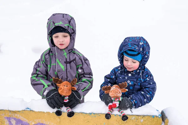 Dwa urocze przedszkola dzieci brata chłopców w zużycie zimą siedzą amou — Zdjęcie stockowe