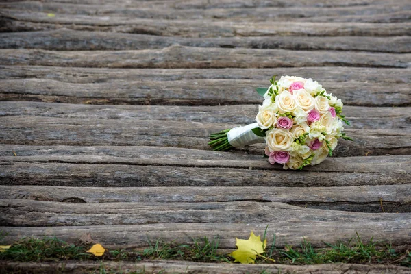 Mooi bruidsboeket liggend op de houten banken — Stockfoto