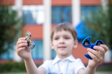 Çocuk iki topluca spinner ile oynarken stres giderici oyuncaklar açık