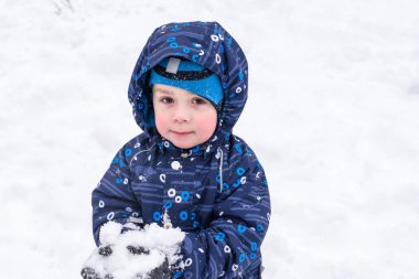 Çocuk karı elinde tutuyor.