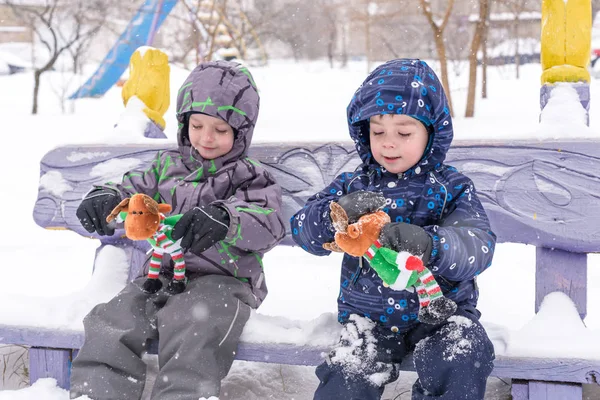 Two adorable preschool kids brother boys in winter wear sit amou — Stock Photo, Image