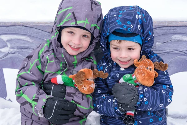 Dwa urocze przedszkola dzieci brata chłopców w zużycie zimą siedzą amou — Zdjęcie stockowe