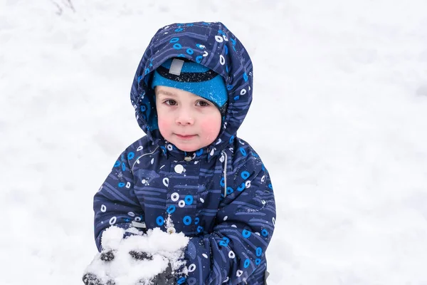 Çocuk karı elinde tutuyor.