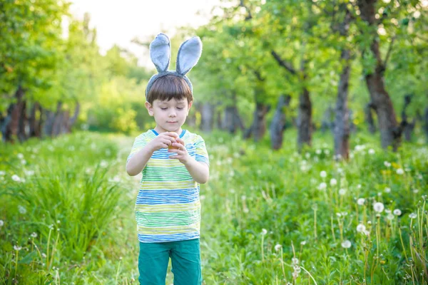 Dzieciak na Easter egg hunt w kwitnące wiosną ogród. chłopiec, wyszukiwanie — Zdjęcie stockowe