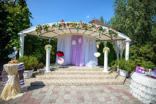 Arco de boda decorado con flores, sillas blancas y ramo de flores —  Fotos de Stock