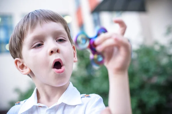Anti stress and relaxation fidgets, spinner for tired people. Boy playing with a fidget spinner.