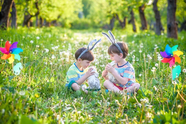 Zwei Jungen im Park, die sich mit bunten Eiern zu Ostern vergnügen — Stockfoto