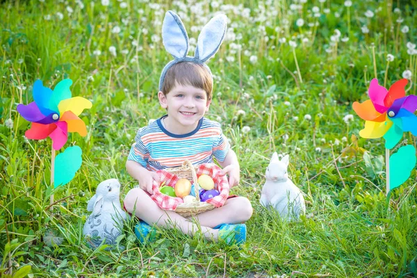 Little boy hunting for easter egg in spring garden on Easter day — Stock Photo, Image