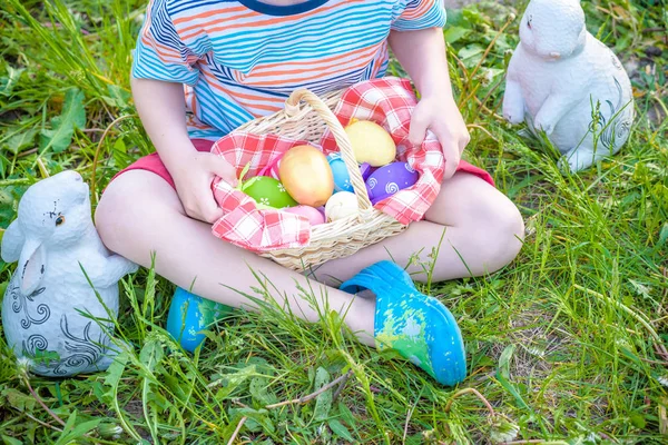 Ładny chłopak uśmiechający się trzymając kosz z kolorowymi jajkami po Wielkanocy — Zdjęcie stockowe