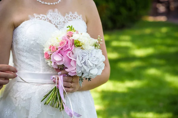 Noiva caucasiana segurando buquê de casamento de várias flores — Fotografia de Stock