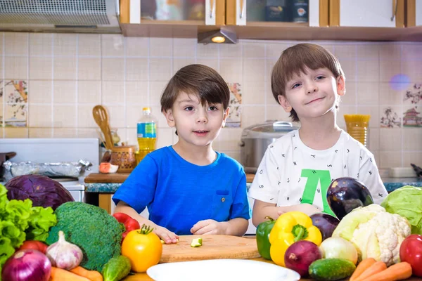 Здорове харчування. Щасливі діти готують і їдять овочевий салат на кухні — стокове фото