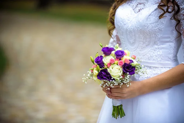 Noiva caucasiana segurando buquê de casamento de várias flores — Fotografia de Stock