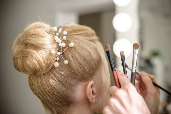 Hairdresser is spraying hair hairspray on the woman hair Stock Picture