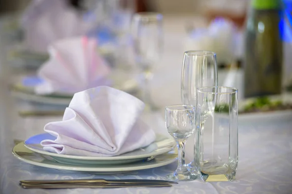 Okulary, widelce, noże, serwetki i dekoracyjnych kwiatów na stole serwowane na obiad w przytulnej restauracji. — Zdjęcie stockowe