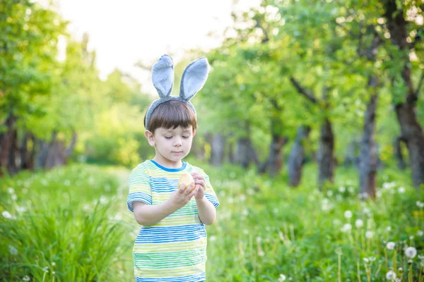 Dzieciak na Easter egg hunt w kwitnące wiosną ogród. chłopiec, wyszukiwanie — Zdjęcie stockowe