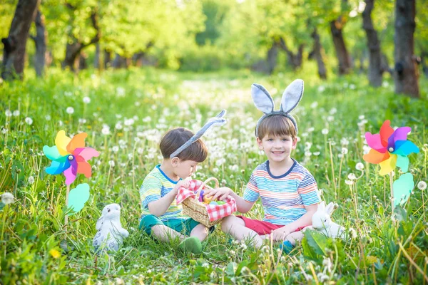 Dwóch chłopców w parku, zabawy z kolorowych jajek na Wielkanoc — Zdjęcie stockowe