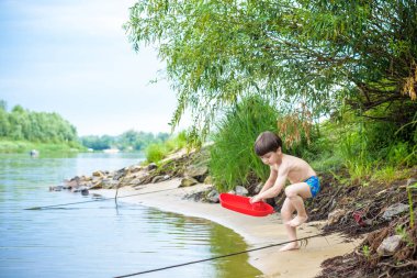 Denizde gemi oyuncakla oynamak bebeğim. Sahilde tatil tatil yaz çocuk os