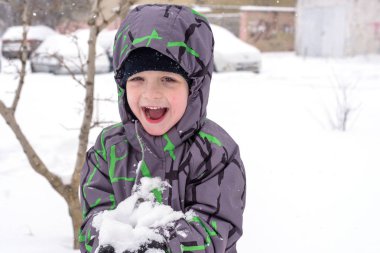 Çocuk karı elinde tutuyor.
