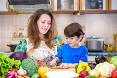 Küçük oğlu kitche ile ayakta genç aşçı anne