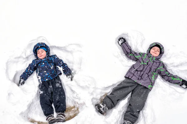 Dwoje rodzeństwa mały dzieciak chłopców w kolorowe zimowe ubrania Dokonywanie s — Zdjęcie stockowe