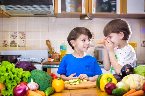 Здорове харчування. Щасливі діти готують і їдять овочевий салат — стокове фото