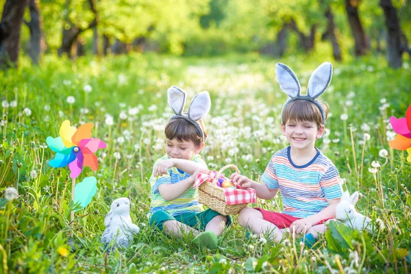 Dva kluci v parku, se baví s barevnými vajíčka na Velikonoce — Stock fotografie