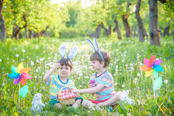Два мальчика в парке, веселятся с цветными яйцами на Пасху — стоковое фото